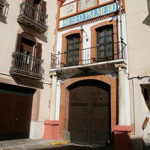 Fachada de edificio cultural con balcones y portada de ladrillo