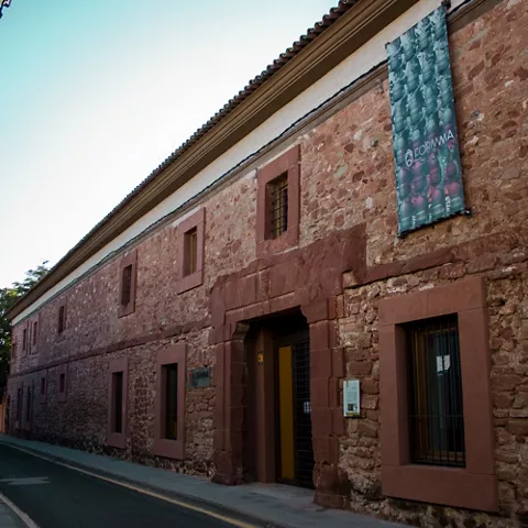 Fachada de edificio histórico de piedra en calle estrecha