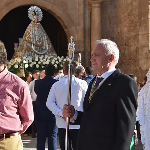 Hombre con vara ceremonial frente a la iglesia