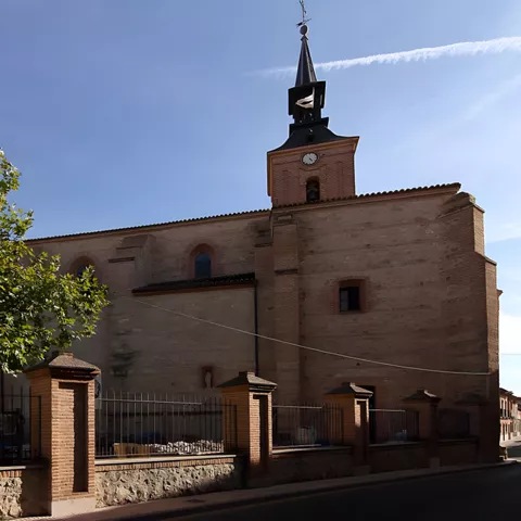 Iglesia de ladrillo vista desde una calle con reja