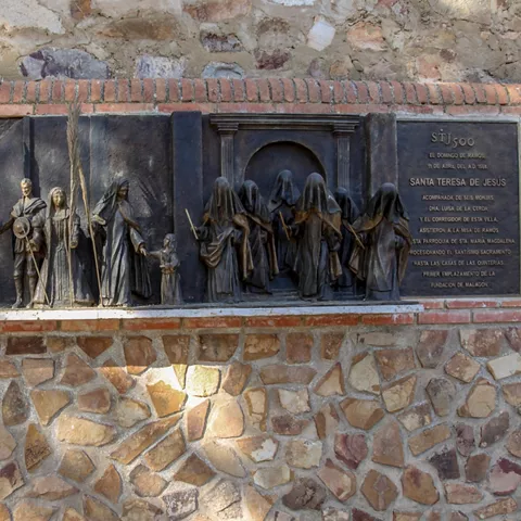 Relieve escultórico de bronce sobre muro de piedra