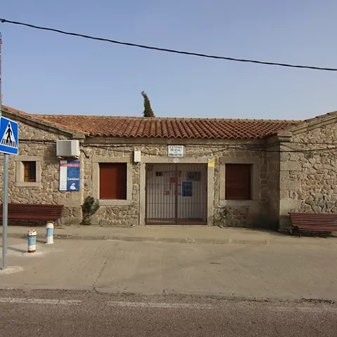 Consultorio de piedra con bancos y paso de peatones