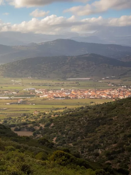 Paisaje montañoso y valle fluvial en el entorno de Guadalmez (Ciudad Real), con el municipio al fondo.