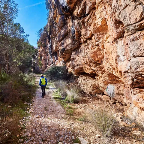 Sendero pedregoso al pie de un gran acantilado de roca.