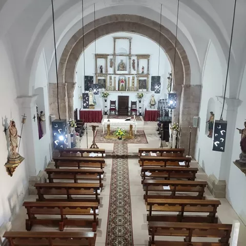 Interior con altar y bancos de madera.