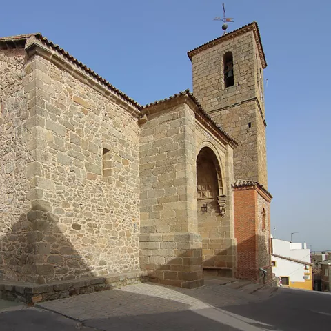 Iglesia de piedra con torre campanario vista lateral