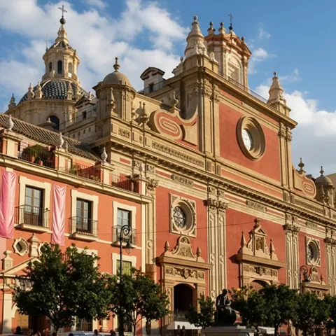 Detalle de iglesia histórica con rosetones y torres ornamentadas al atardecer.