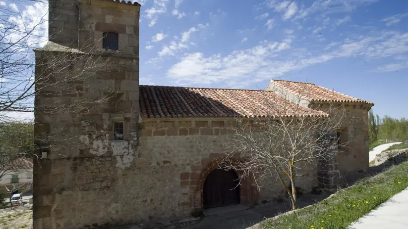 Iglesia histórica de piedra en paisaje rural.