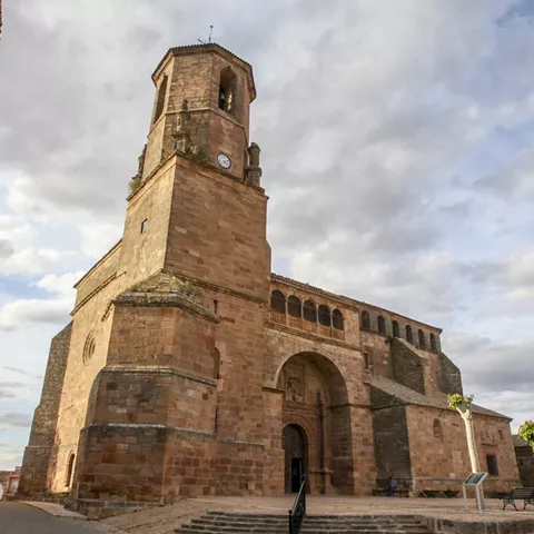 Iglesia de piedra con torre y arco de entrada.