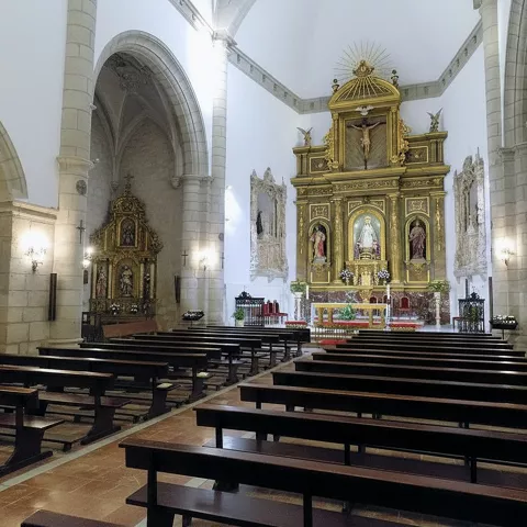 Interior con nave amplia y retablo dorado.