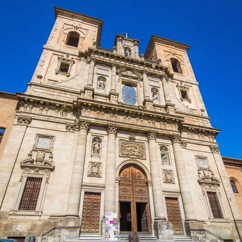 Entrada principal de iglesia con escalinata y puertas talladas.