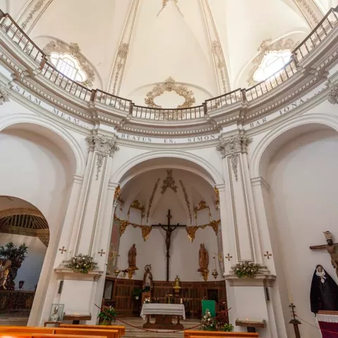 Nave principal con arcos y crucifijo sobre el altar.