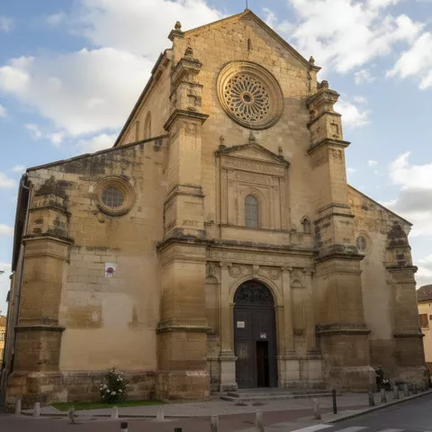 Entrada monumental de iglesia con gran rosetón y hornacina central.