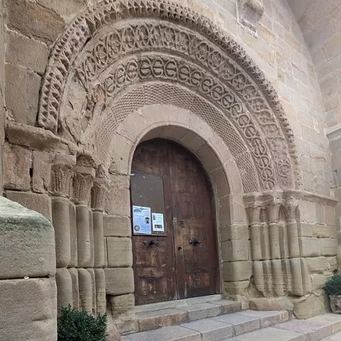 Entrada con arco semicircular y escalones de piedra.
