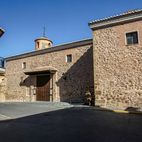 Fachada de iglesia de piedra con puerta de madera.