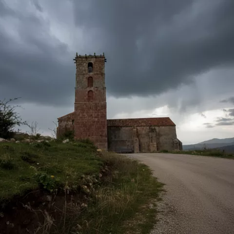 Iglesia rural junto a un camino bajo cielo nublado y paisaje montañoso.