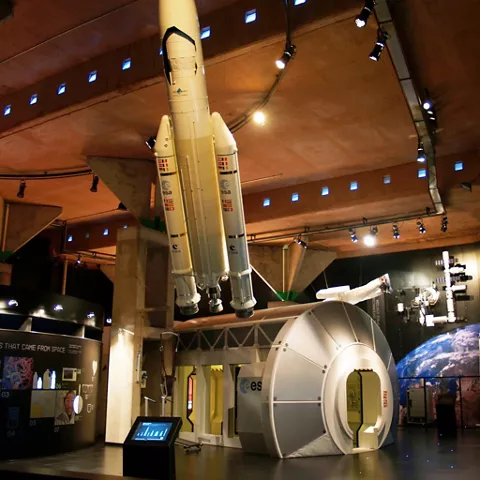 Sala expositiva con cohete y módulos espaciales