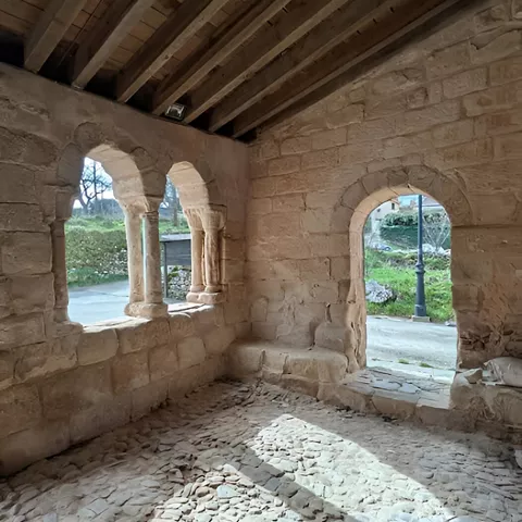 Interior con arcos de medio punto y suelo empedrado.