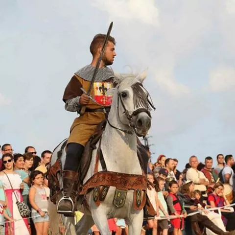 Personajes medievales coronados paseando entre el público