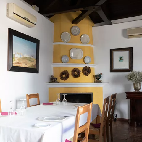 Salón clásico con chimenea amarilla y vajilla decorativa