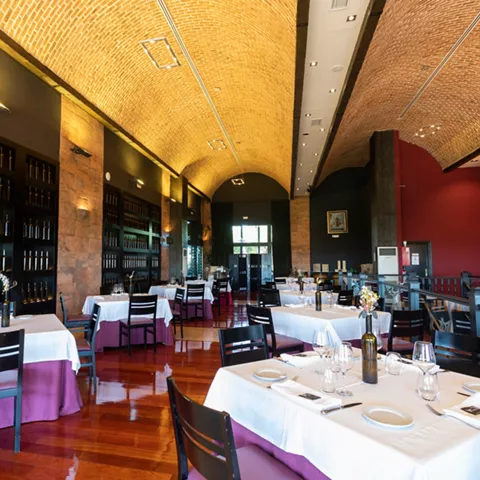 Salón amplio con techo abovedado y mesas vestidas