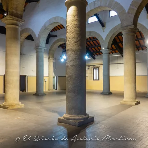 Sala interior con columnas y arcos de piedra.