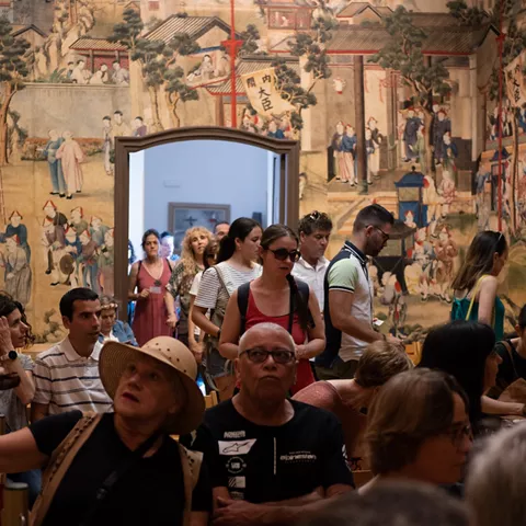 Visitantes en sala con mural ilustrado.