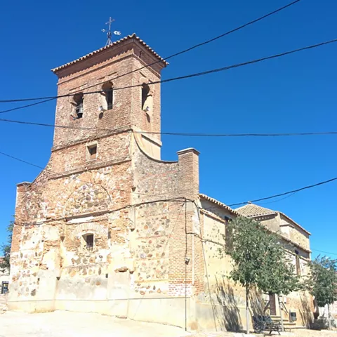 Iglesia de ladrillo visto con campanario y cables aéreos