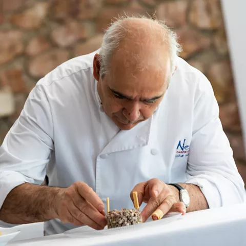 Chef emplatando plato gourmet con detalle