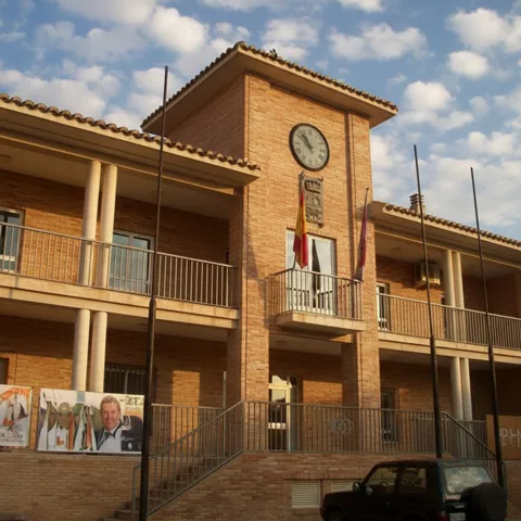 Ayuntamiento de Mestanza (Ciudad Real), edificio consistorial de ladrillo con reloj en la fachada principal.