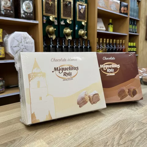 Cajas de dulces en un mostrador, con estanterías de tienda al fondo.