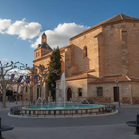 Plaza con fuente frente a iglesia de piedra
