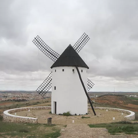 Molino de viento tradicional con paisaje rural.