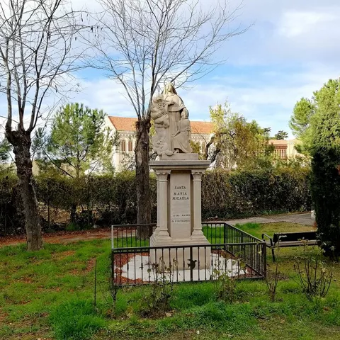 Monumento religioso en jardín urbano.
