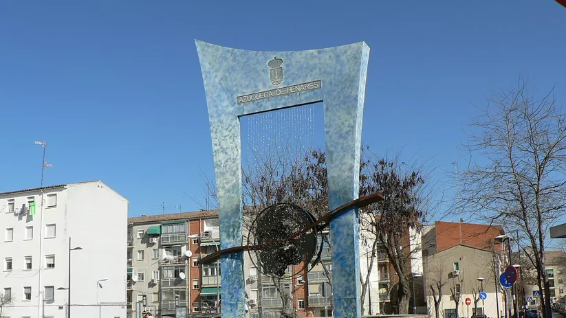 Escultura urbana moderna en una rotonda rodeada de edificios