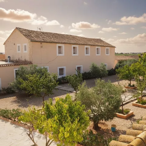 Antiguo edificio agrícola con patio y árboles