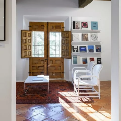 Rincón luminoso con sillones y libros.