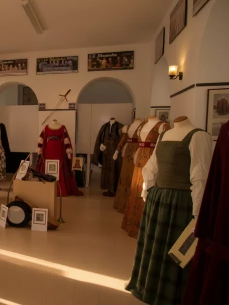 Exposición de trajes tradicionales en sala blanca