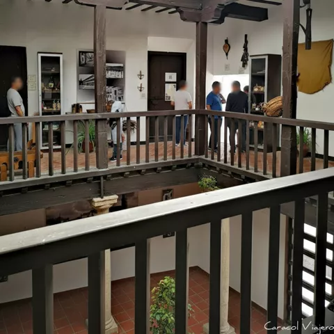 Patio interior con galería de madera, barandilla y salas expositivas alrededor.