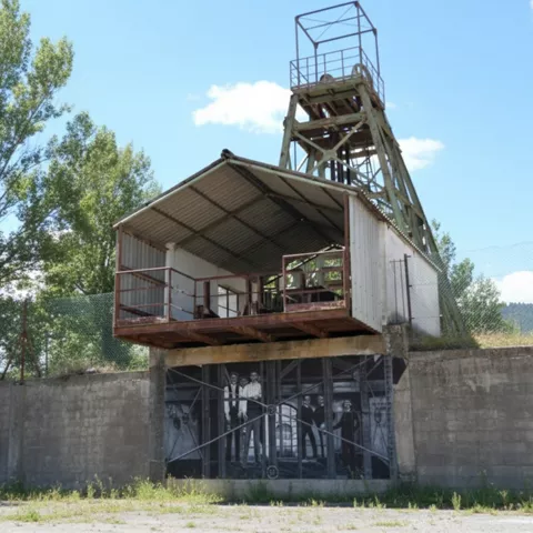 Torre metálica de extracción junto a edificio.