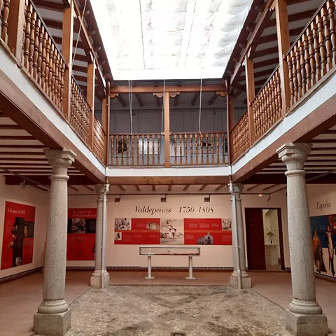 Patio interior con columnas de piedra y paneles expositivos