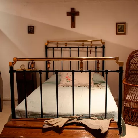 Dormitorio antiguo con cama de hierro