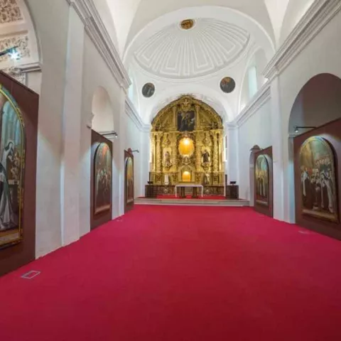 Interior de iglesia con pinturas religiosas y altar barroco