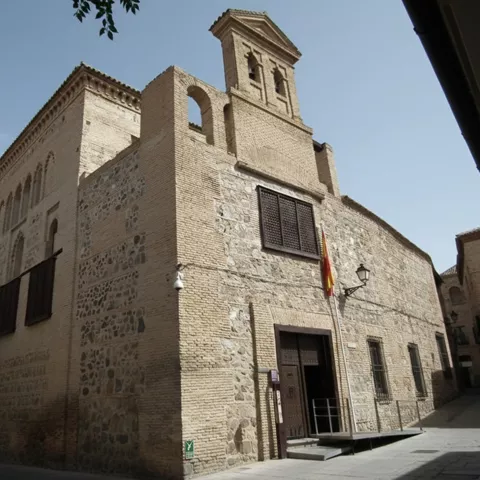 Fachada exterior de edificio histórico en calle estrecha.