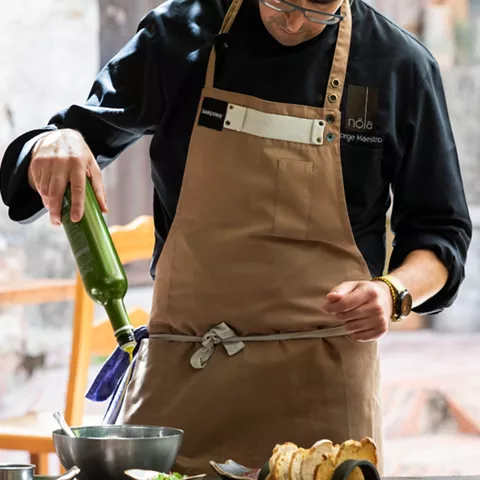 Cocinero aliñando ensalada con aceite