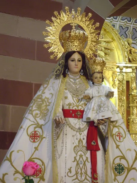 Virgen con manto bordado y niño coronado.
