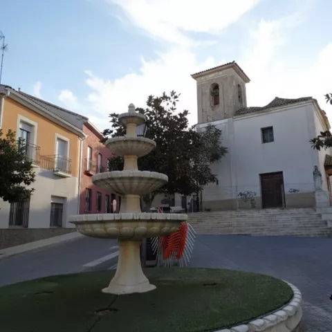 Fuente escalonada frente a una iglesia en una plaza