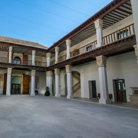 Claustro amplio con columnas, galerías superiores y escalinata lateral.