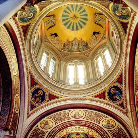 Interior con cúpula pintada y mosaicos dorados.