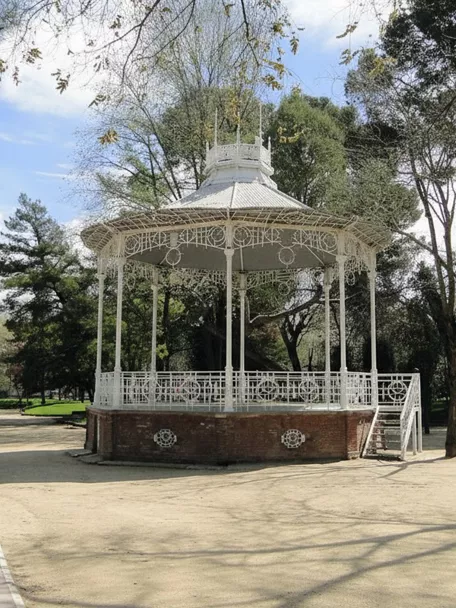 Templete blanco rodeado de árboles y senderos.